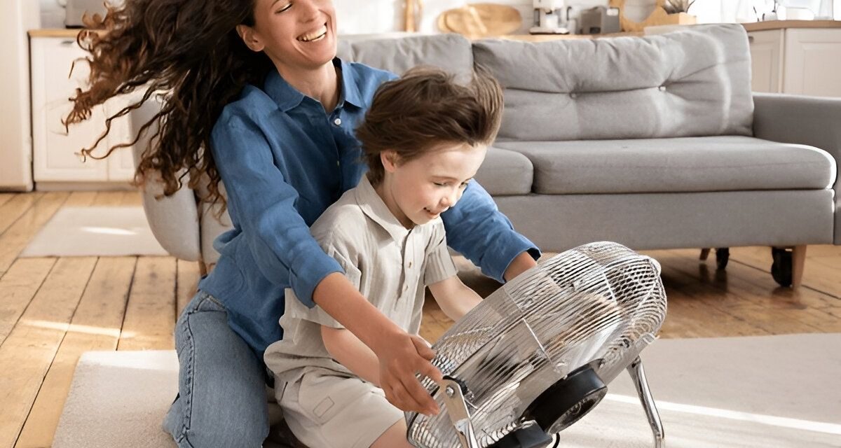 Woman and child playing with a fan indoors, emphasizing comfort and cooling solutions in home environments, relevant to HVAC services in Bucks County.