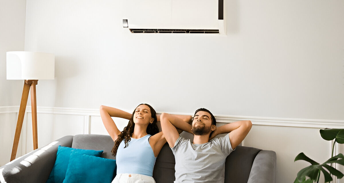 Couple relaxing on a couch enjoying cool air from a modern air conditioning unit, emphasizing comfort and efficient HVAC solutions in Montgomery County.