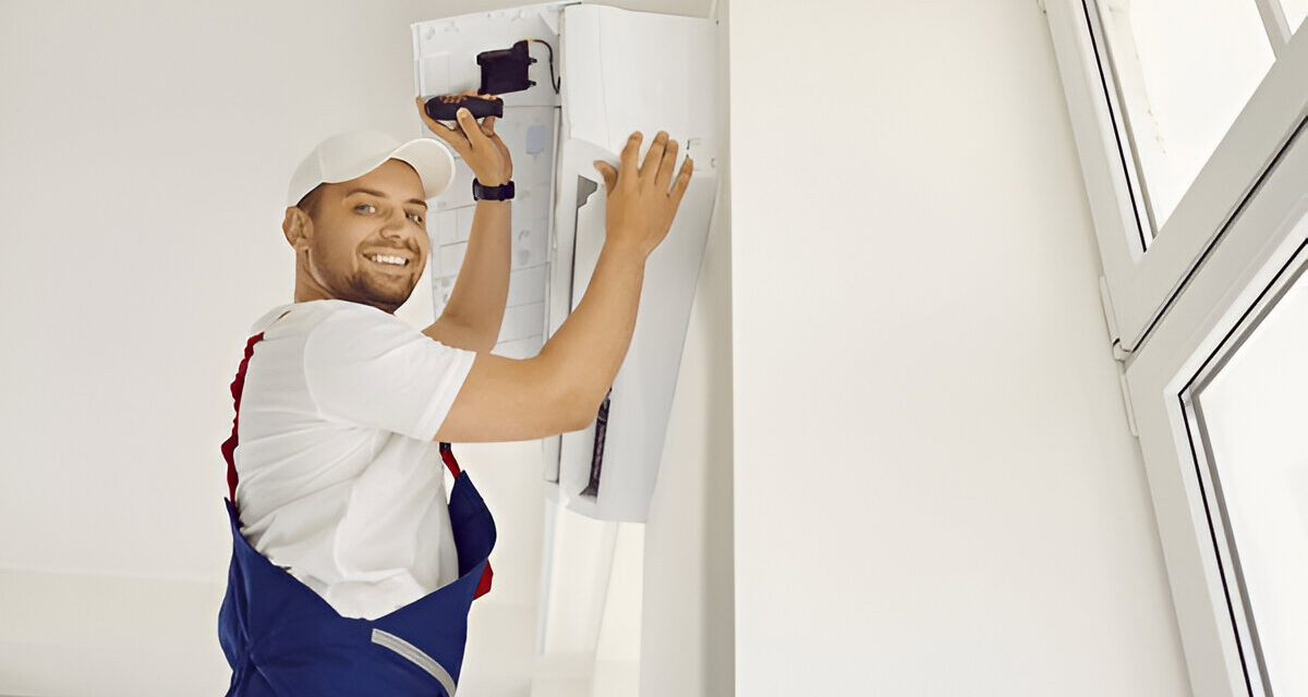 HVAC technician performing an AC tune-up service, smiling while working on an air conditioning unit in a bright, modern interior.